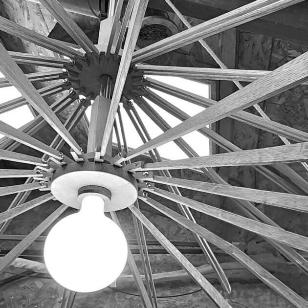 Enchevêtrement d'éléments en bois fins et élégants de ce lustre intitulé PAQUERETTE